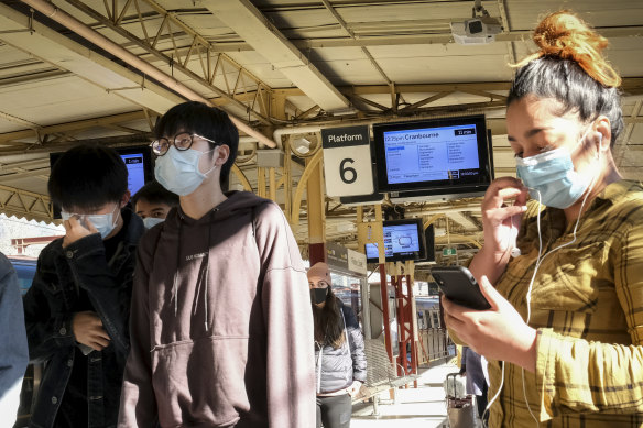 Public transport users wearing protective face masks at Flinders Street Station in June.