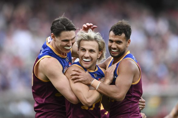 Brisbane’s Kai Lohmann (centre) celebrates one of his four goals in the grand final with teammates Eric Hipwood and Callum Ah Chee.