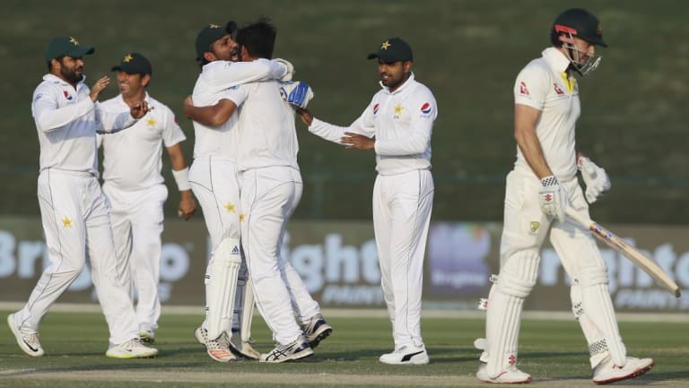 Bowled over: Pakistan celebrate taking the first wicket of Australia's second innings, after Shaun Marsh (right) was dismissed by Sarfaraz Ahmed (third left).