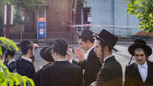 Members of the Adass Israel community have gathered outside their torched synagogue on Friday morning.