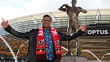 Nicky Winmar poses with his statue during its unveiling in 2019.