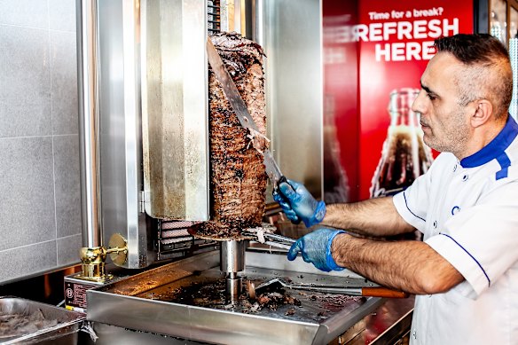 O chef veterano Celal Per cortando fatias de carne de um doador yaprak (folha).
