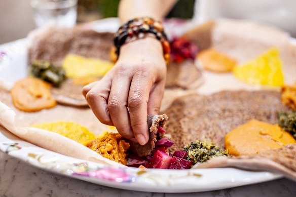 Adulis Restaurant food review Good Food/WAtoday. Eaters tear off bite-sized pieces of injera and use it to scoop up food.
