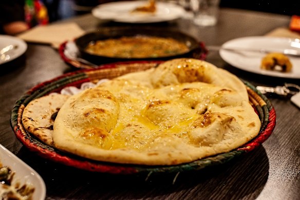 Roghni naan is studded with white sesame seeds and brushed with butter.