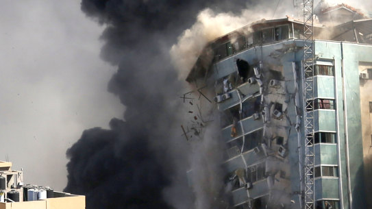 The building housing the offices of the AP and other media in Gaza City collapses after it was hit by an Israeli airstrike. 