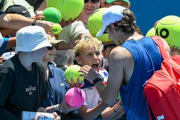 Alex de Minaur signs autographs for excited fans.