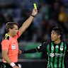 Referee Alex King shows the yellow card to Riku Danzaki during an A-League match in April.