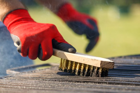 Use uma escova de aço com cabo de madeira para esfregar a placa de churrasco.