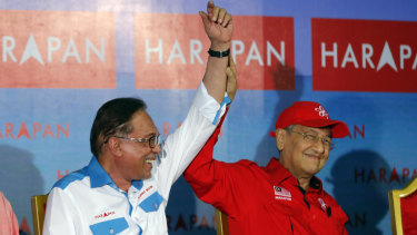 Malaysia's Prime Minister Mahathir Mohamad, right, raises hand of Malaysia's reform icon Anwar Ibrahim during a rally in Port Dickson, last week.