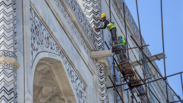 Laborers from the Archeological Survey of India clean the Taj Mahal.
