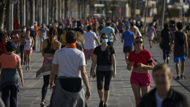People exercise on a seafront promenade in Barcelona