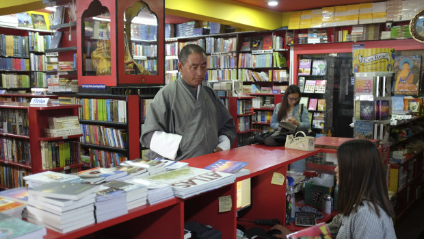 A customer buys a book at DSB Books in Thimphu, which claims to be the oldest bookstore in Bhutan
