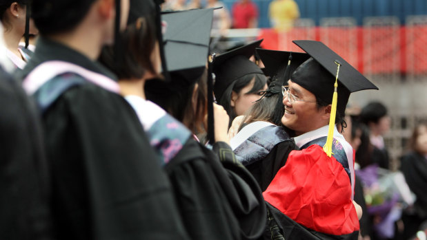 Chinese students attend a graduation ceremony at Fudan University in Shanghai. The university is one of three that have revised their charters to reflect Communist Party doctrine.