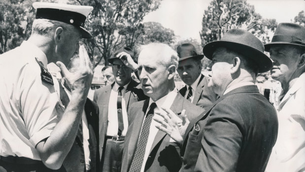 Senior police talk with Mr. Vernon Wilcox, Victorian Minister for Transport (centre) and Mr. E. H. Brownbill, Chairman of the Victorian Railway Commission (right) at the accident.