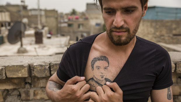 Munther al-Sudani, the brother of Captain Harith al-Sudani, shows off a tattoo of his late brother in Baghdad.