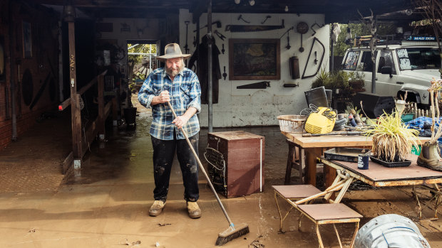 Les Davidson sweeps water in the front yard of his Traralgon home after the recent flooding in the Latrobe Valley.