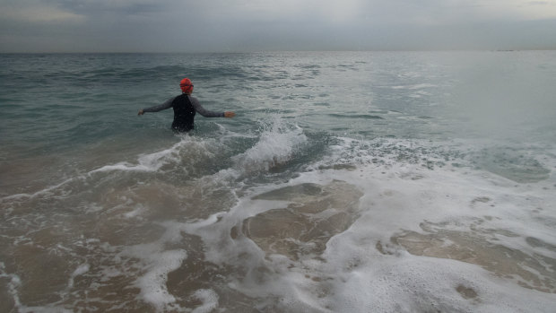 A swimmer at Coogee as storm clouds hover.