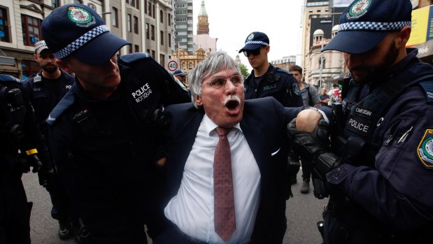 A man is taken away by police during the protest in Sydney.