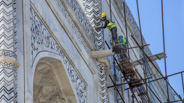 Laborers from the Archeological Survey of India clean the Taj Mahal.
