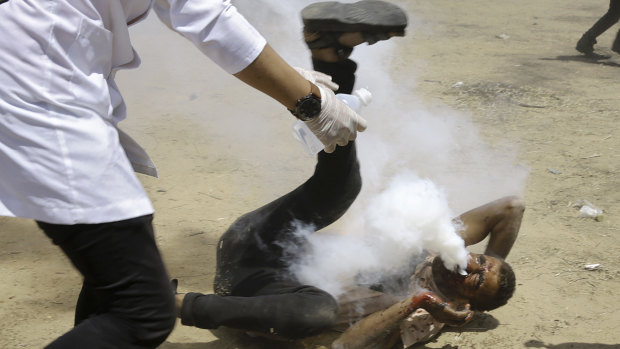 A Palestinian medic treats a protester shot in the face with a teargas canister during protests in the Gaza Strip in June. 