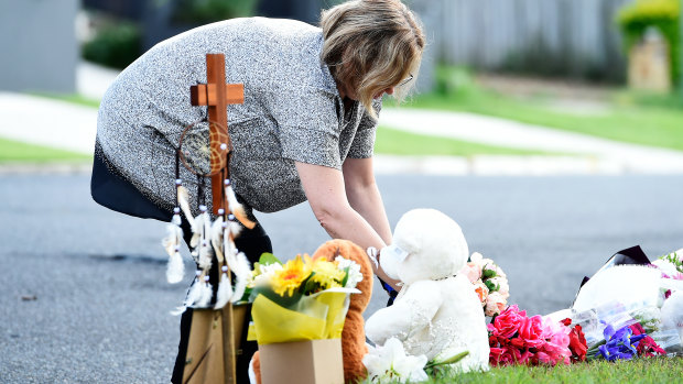 Mourners pay their respects at the scene where Ms Clarke and her children were killed in a deliberately lit car fire in Camp Hill.