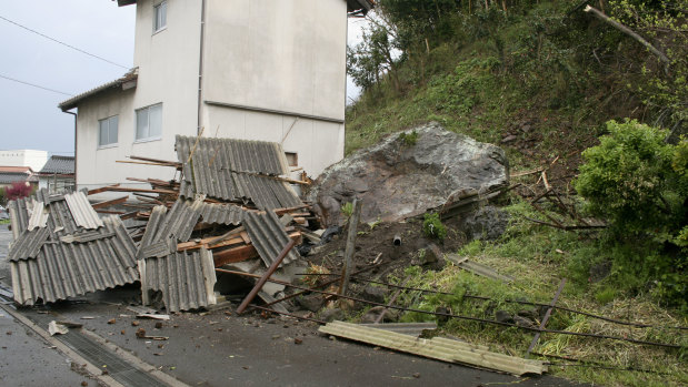 A rock sits on the ground near a house, following a landslide caused by the earthquake in Ohda, Shimane prefecture, western Japan, on Monday.
