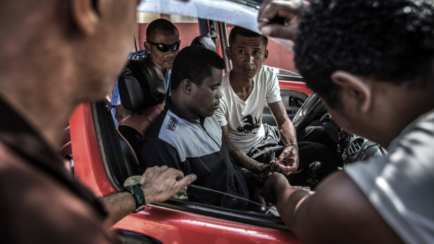 Commissionaires trade vanilla from a vehicle in Sambava.