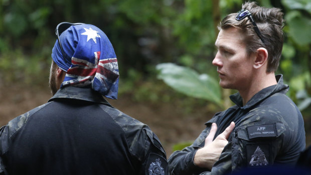 Australian Federal Police and Defence Force personnel talk each other near a cave complex where 12 boys and their soccer coach went missing, in Mae Sai, Chiang Rai province, in northern Thailand.
