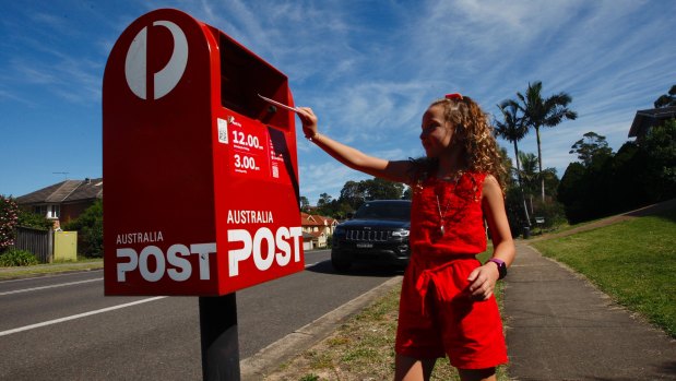 Eight-year-old Scarlett Frost drops a letter off at the local postbox. Writing letters has become one of her favourite pastimes.