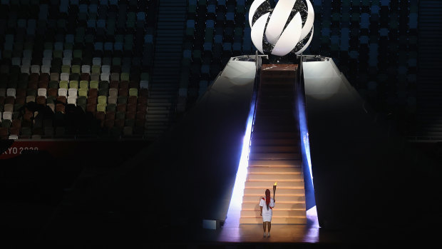 Naomi Osaka carries the Olympic torch.