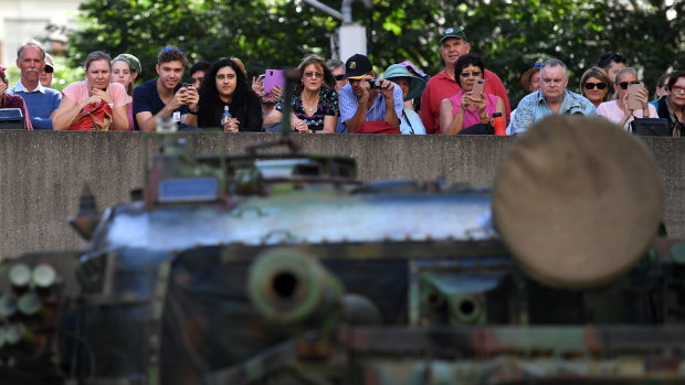 Spectators watch an army tank go by during the Anzac Day parade.