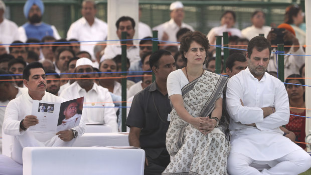 Congress Party president Rahul Gandhi, right, with his sister and party general secretary Priyanka Gandhi Vadra sit as her husband Robert Vadra, left, reads a booklet on Rajiv Gandhi on the anniversary of his death.