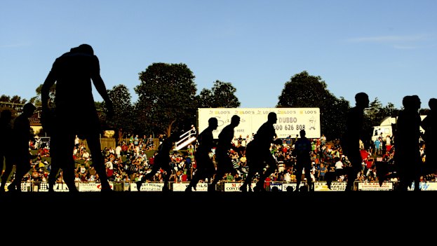 Raiders and Bulldogs players warm-up before a pre-season game at Dubbo’s Apex Oval in 2010.