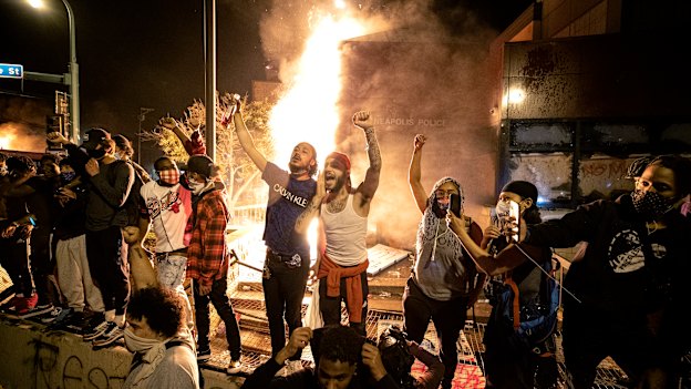 People stand outside the Minneapolis police 3rd Precinct building after fires were set at the building on Thursday, May 28, 2020, during demonstrations over the death George Floyd.