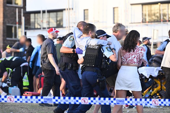One of the wounded victims is helped by police officers on the day of the Bondi Beach attack in December 2025.