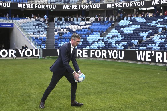 Premier Dominic Perrottet kicks a ball during the community open day at Allianz Stadium on Sunday.