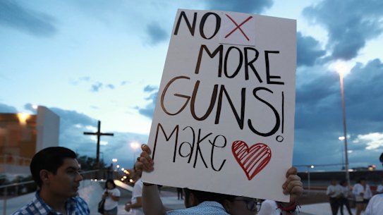 People gather in Juarez, Mexico, on Saturday night in a vigil for the 3 Mexican nationals who were killed in an El Paso shopping-complex shooting.