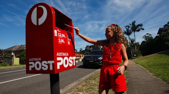 Eight-year-old Scarlett Frost drops a letter off at the local postbox. Writing letters has become one of her favourite pastimes.