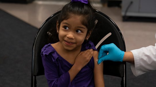 Elsa Estrada, 6, smiles at her mother prior to receiving the Pfizer COVID-19 vaccine in Santa Ana, California.