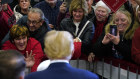 Former President Donald Trump greets supporters during a rally in Iowa.