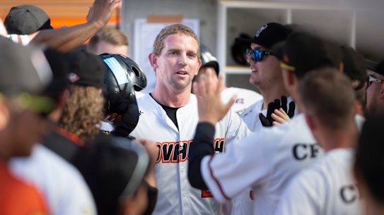 Canberra Cavalry's David Kandilas celebrates his home run in the dugout.
