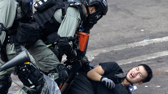 Riot police pin down a protester trying to flee from the Hong Kong Polytechnic University.
