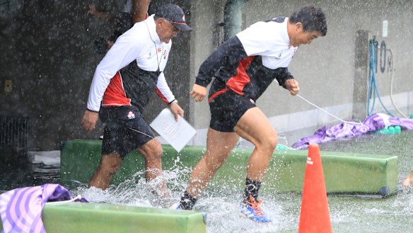 Japan players soaked before their captain's run in Tokyo.