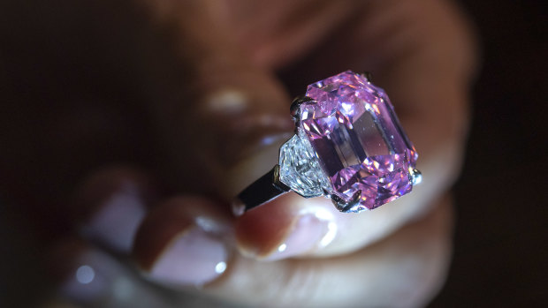 A Christie's employee displays an 18.96-carat fancy vivid pink diamond during a preview.