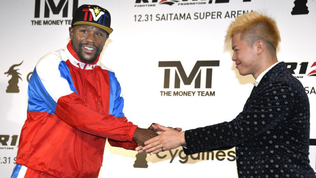 Floyd Mayweather shakes hands with kickboxer Tenshin Nasukawa at Monday's press conference.