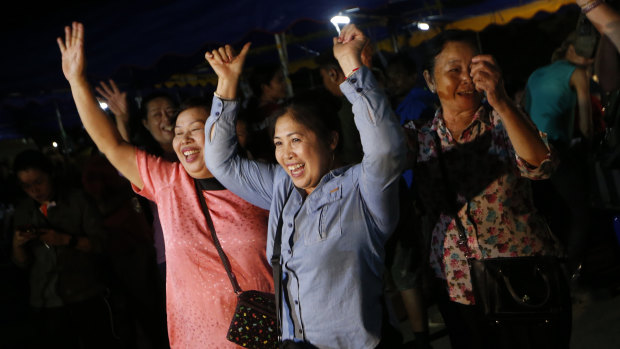 People celebrate after divers evacuated some of the 12 boys and their coach trapped at Tham Luang cave.