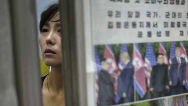 A North Korean woman reads newspapers fronting the news on US President Donald Trump's summit with North Korean leader Kim Jong-un.