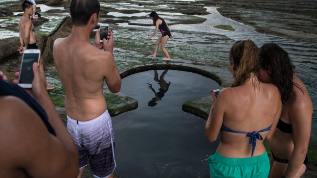 Tourists pose for photographs at the Figure 8 Pools in 2016. 