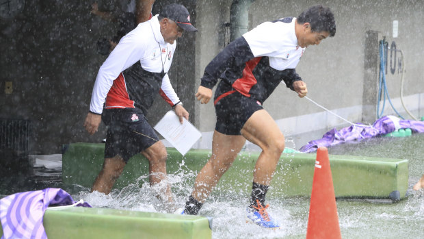 Japan players soaked before their captain's run in Tokyo.
