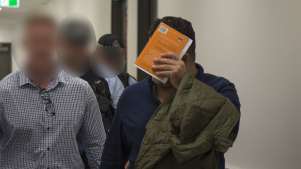 Mr Radhi is taken into custody at Brisbane Airport this month.